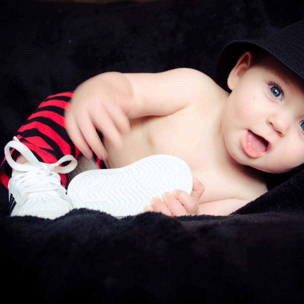 Забавный улыбающийся ребенок в черной панаме