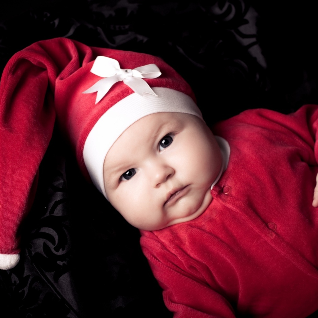 Грудной ребенок в красном новогоднем костюме