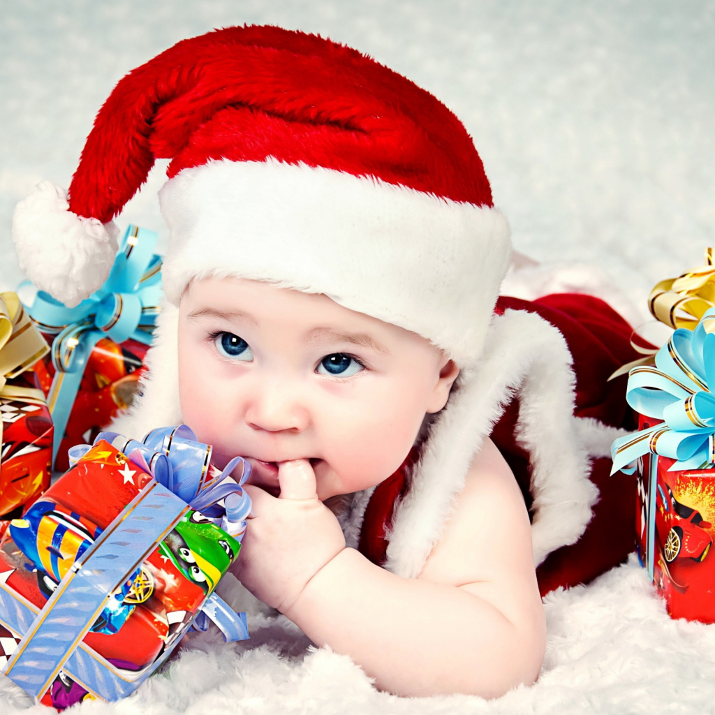 Маленький ребенок в новогоднем костюме с подарками