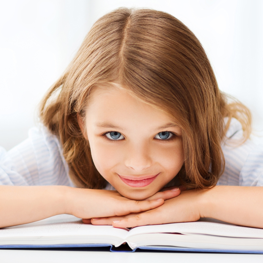 Маленькая голубоглазая девочка школьница с книгой 