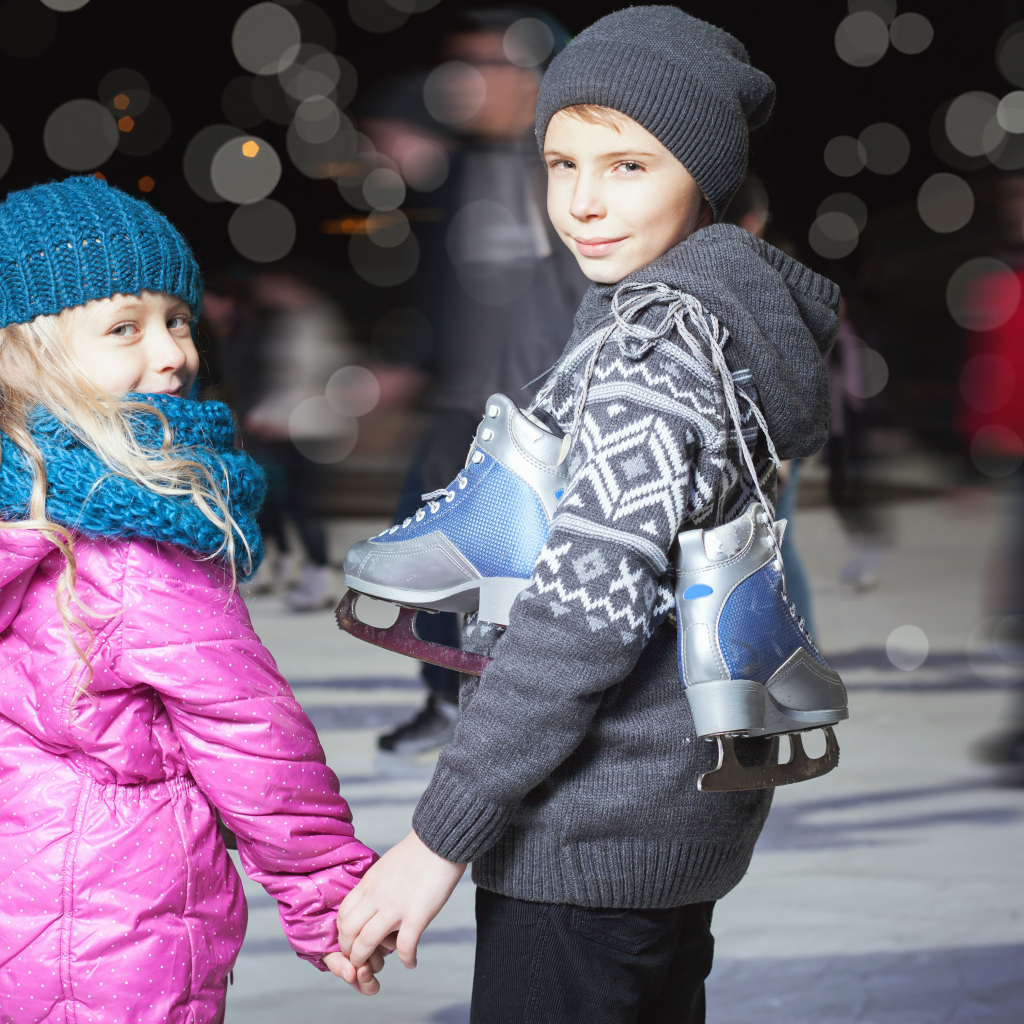 Маленькие мальчик и девочка на катке