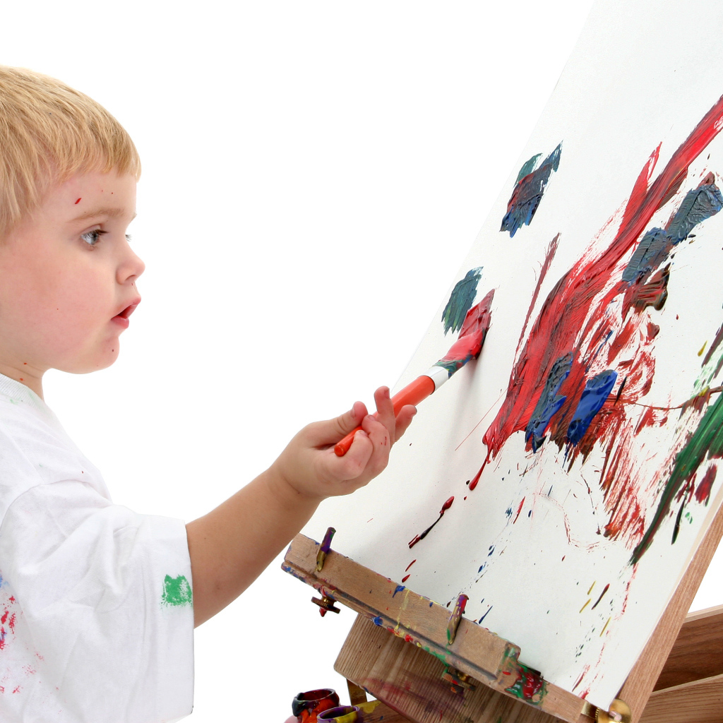 Маленький мальчик рисует красками 