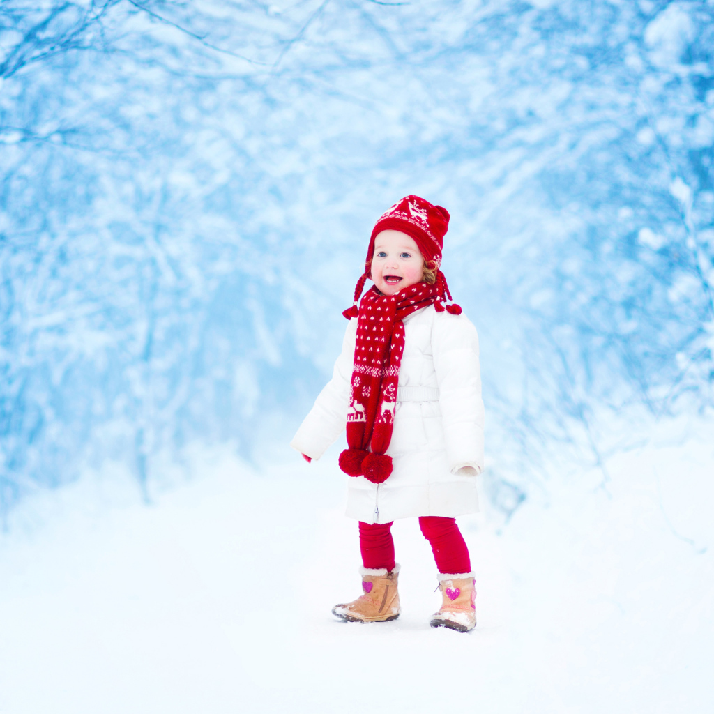 Маленькая веселая девочка в зимнем лесу