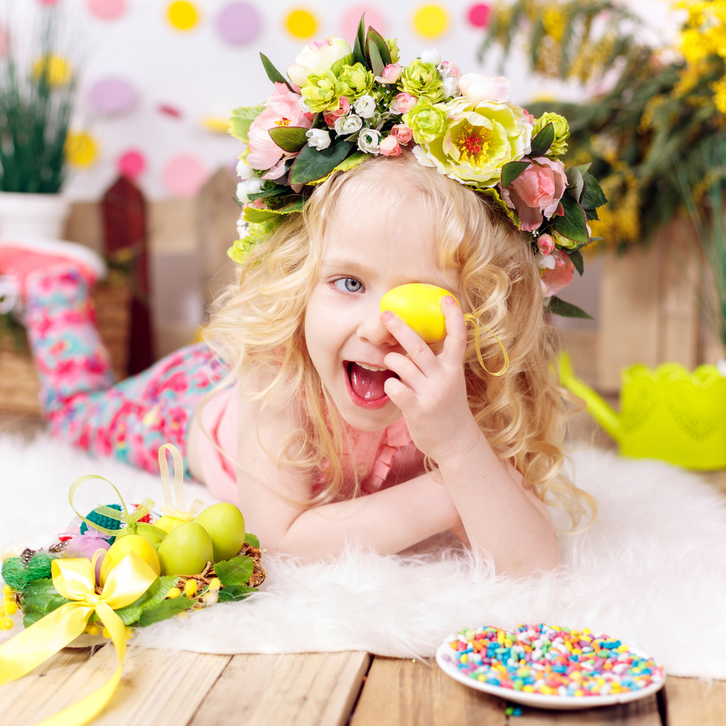 Маленькая веселая девочка с пасхальными яйцами