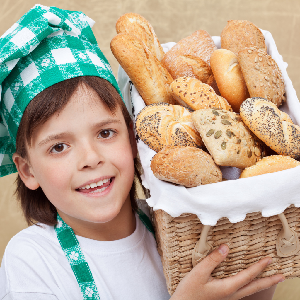 Маленькой поваренок с корзиной свежей выпечки 