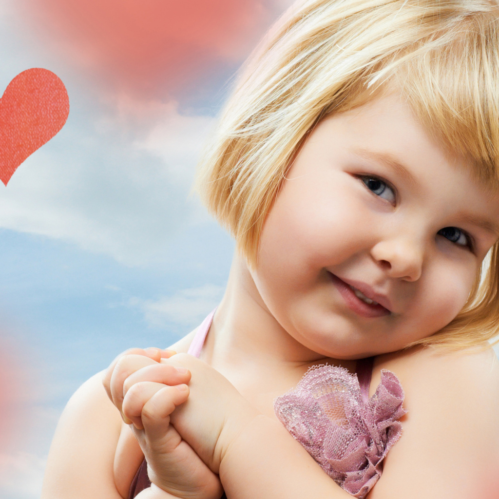 Маленькая милая девочка на фоне красных сердечек