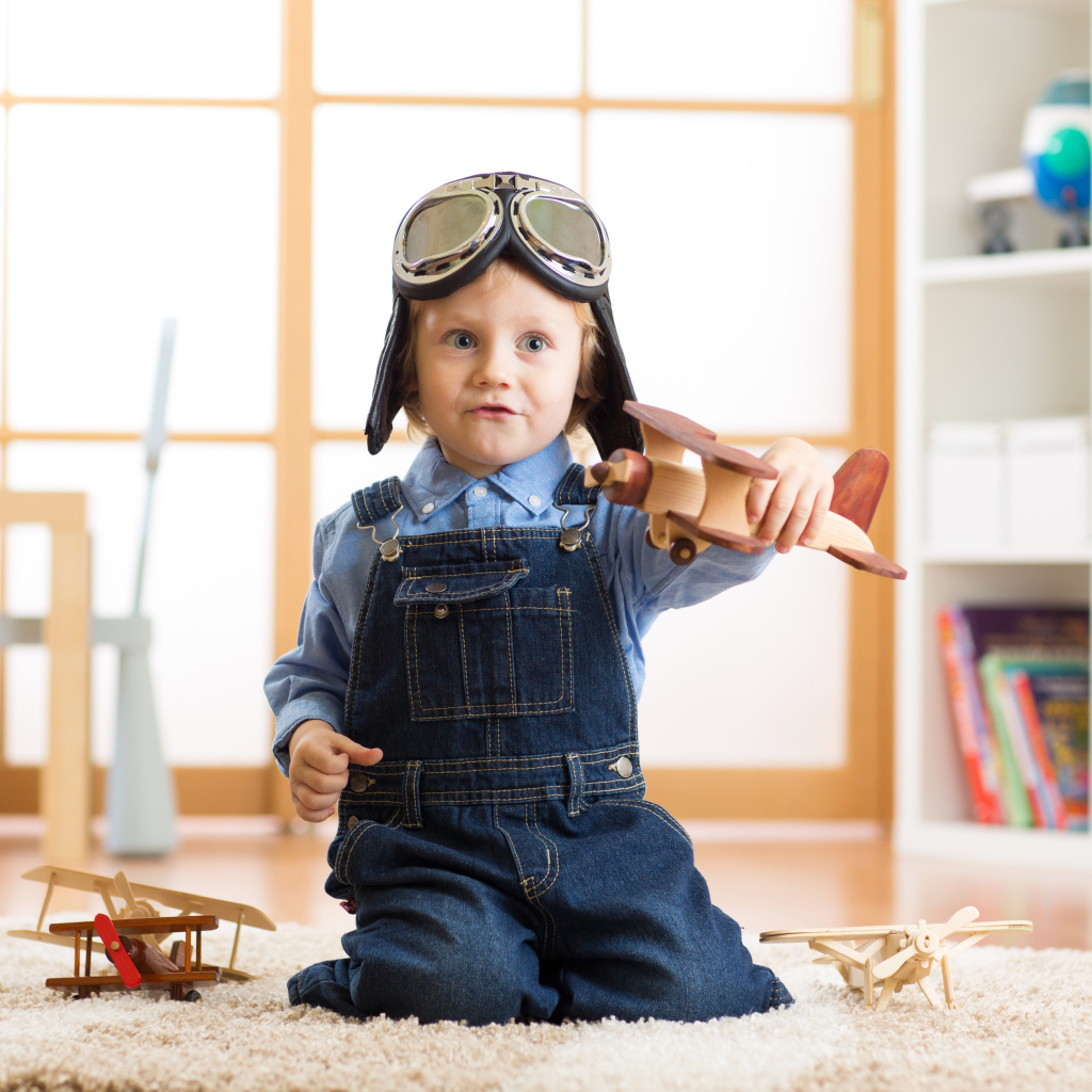 Маленький будущий летчик играет с самолетом