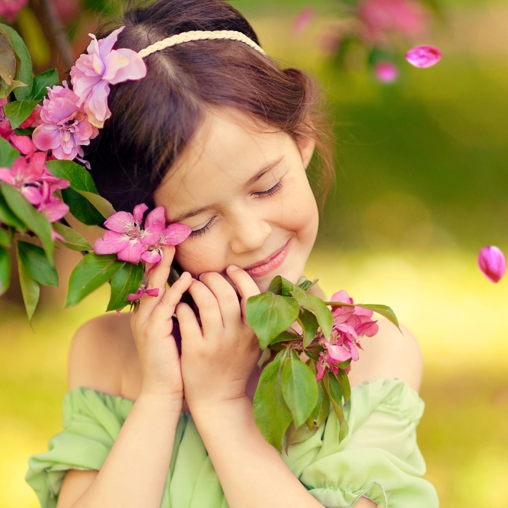 Маленькая девочка обнимает ветку с розовыми цветами