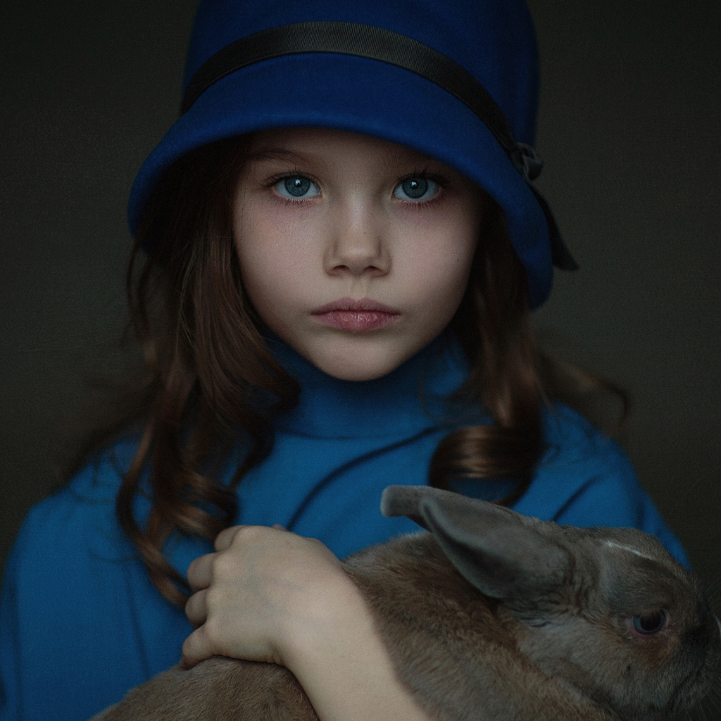 Маленькая девочка в синей шляпе с кроликом