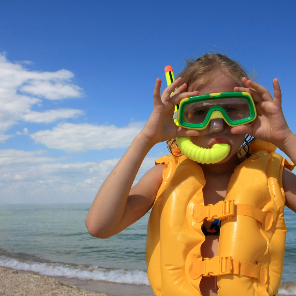 Маленькая девочка в маске и спасательном жилете на море