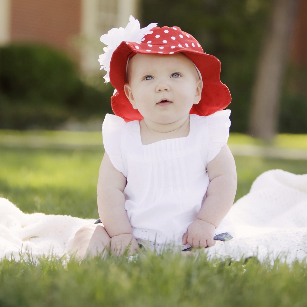 Маленькая девочка в белом платье и красной шляпе