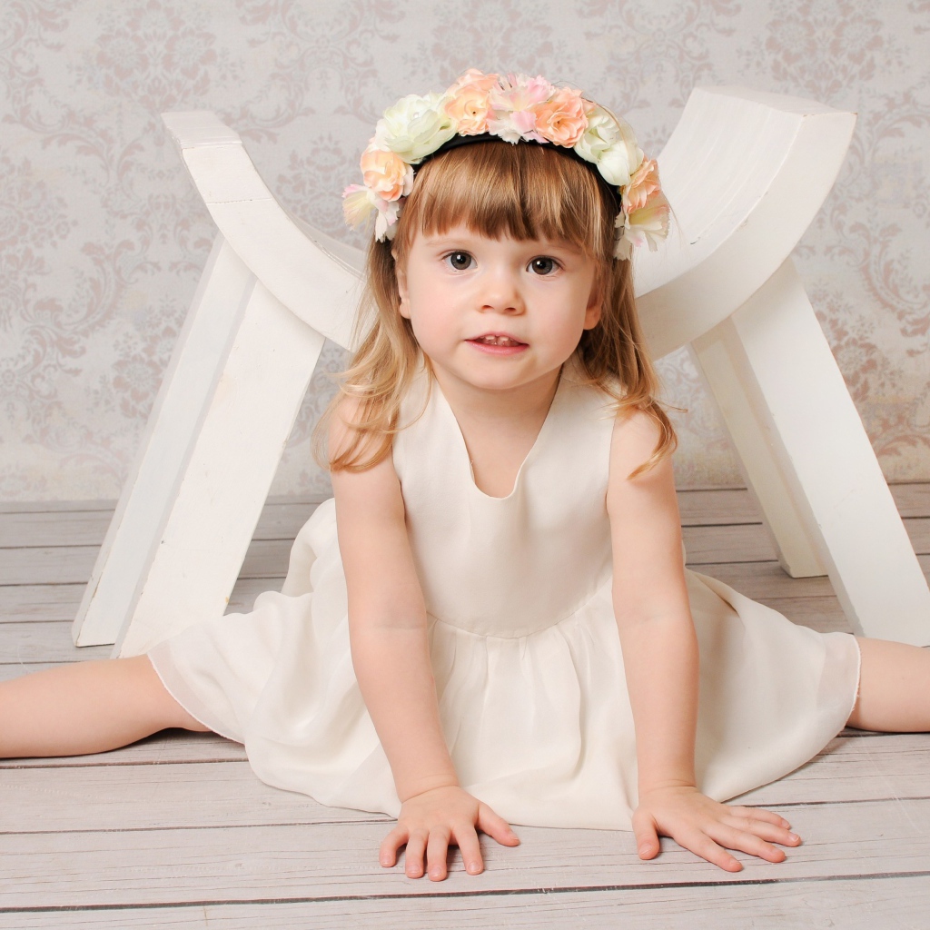 Маленькая девочка сидит на шпагате