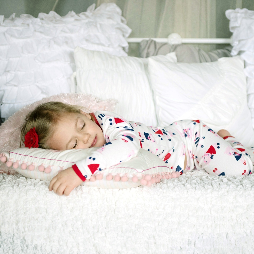 Маленькая девочка спит на подушке