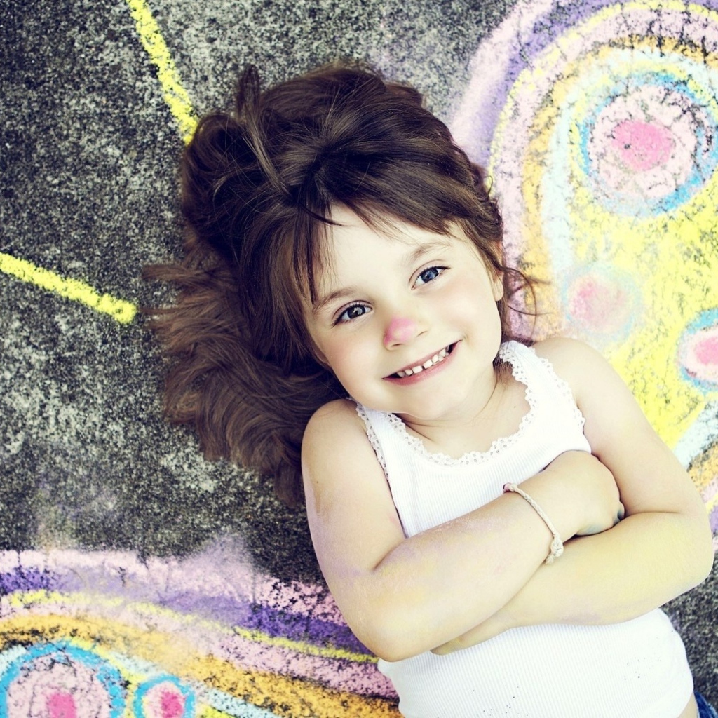 Маленькая девочка нарисовала крылья бабочки на асфальте