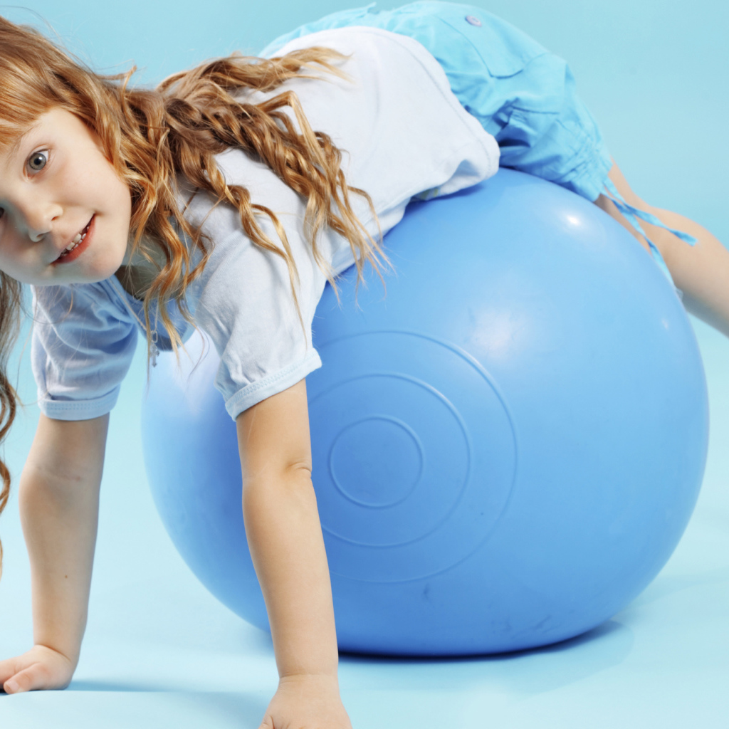 Маленькая девочка с большим голубым мячом