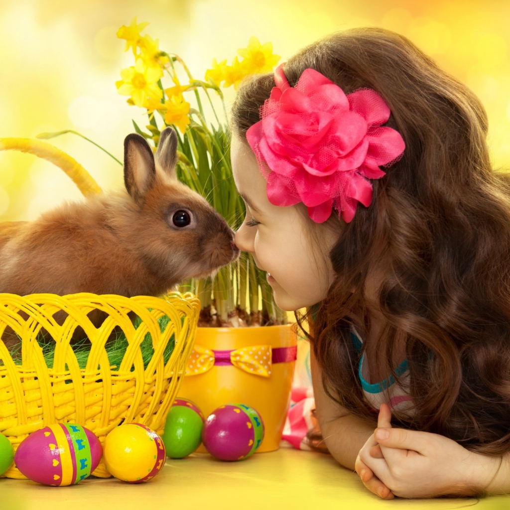 Маленькая девочка с кроликом в корзине на праздник Пасха