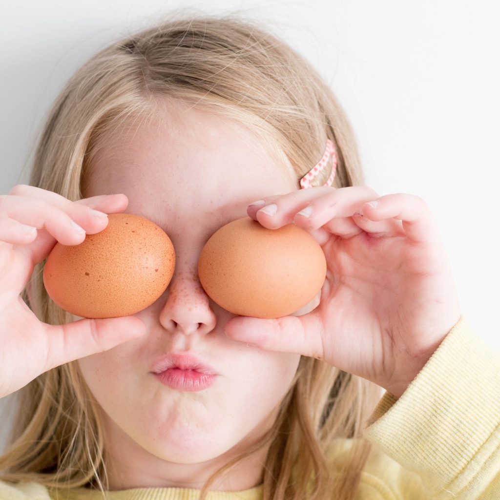 Маленькая девочка с яйцами в руках