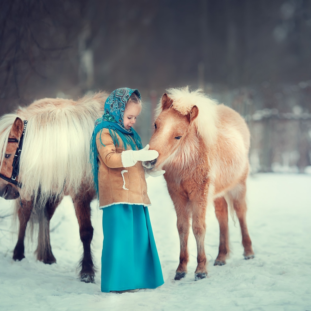 Маленькая девочка с пони зимой