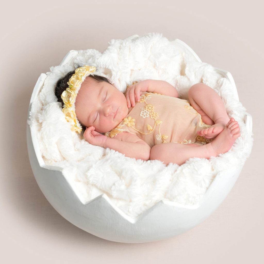 Маленькая новорожденная девочка в забавной колыбели