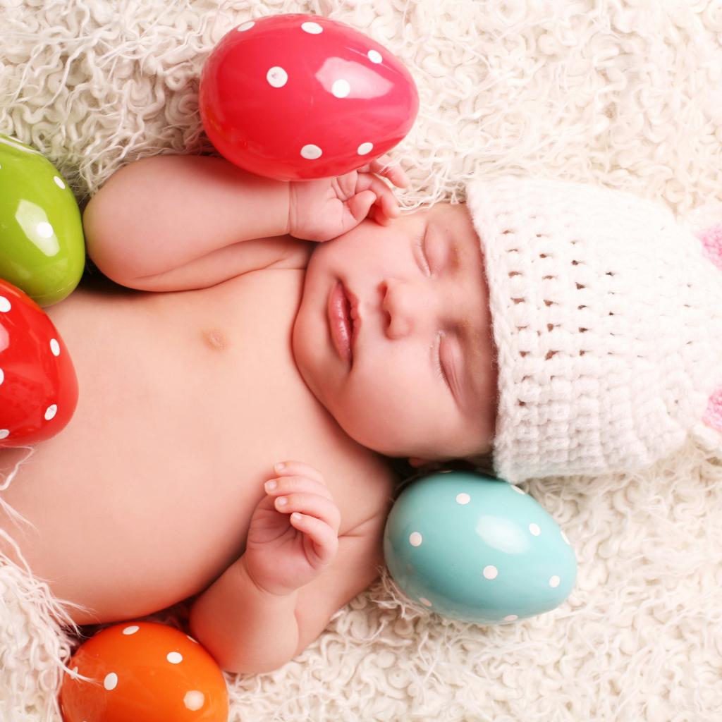 Маленький спящий ребенок с пасхальными яйцами
