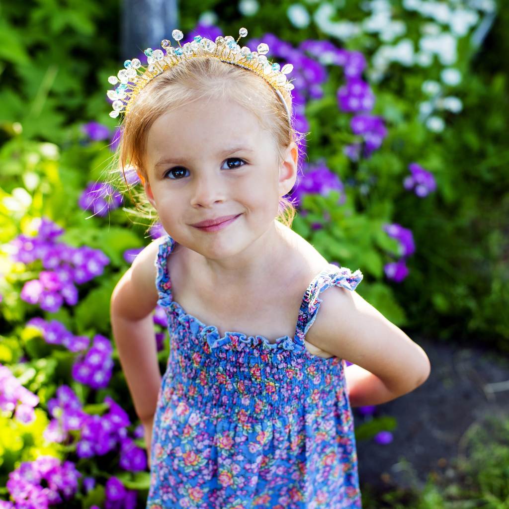 Маленькая улыбающаяся девочка с украшением в волосах 