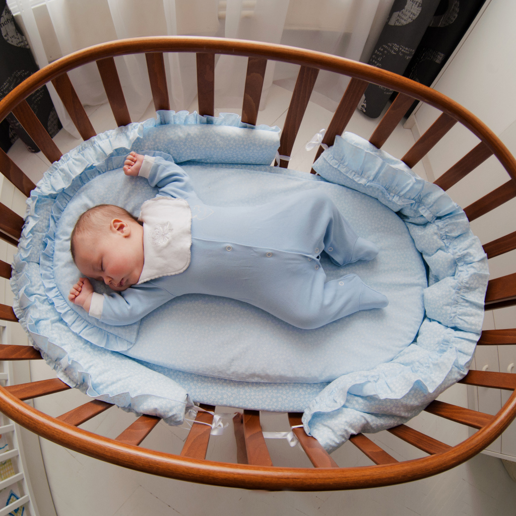 Спящий грудной ребенок в кроватке