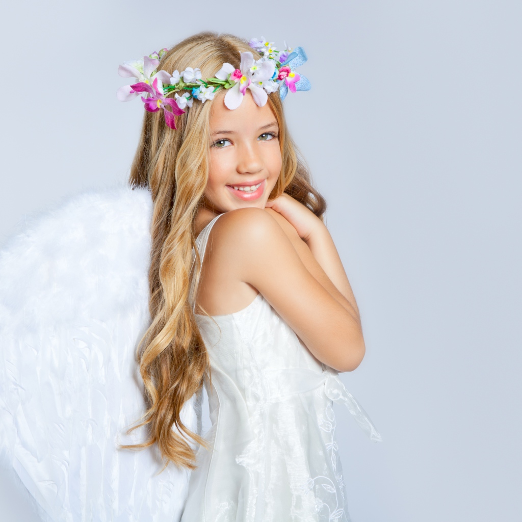 Улыбающаяся милая девочка в костюме ангела