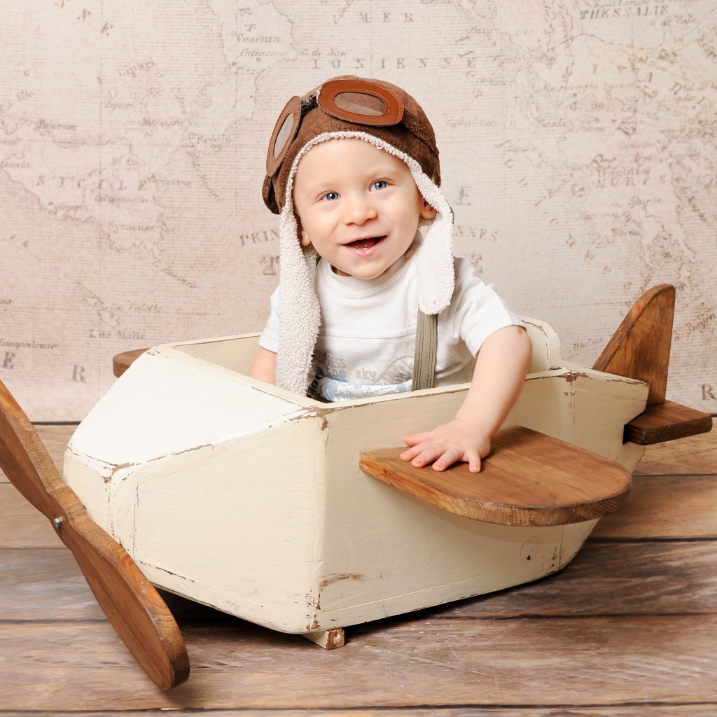 Улыбающийся маленький мальчик в игрушечном самолете