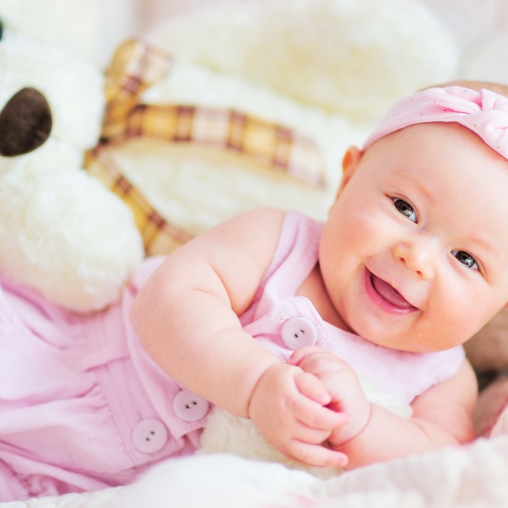 Улыбающаяся маленькая девочка с большим плюшевым медведем