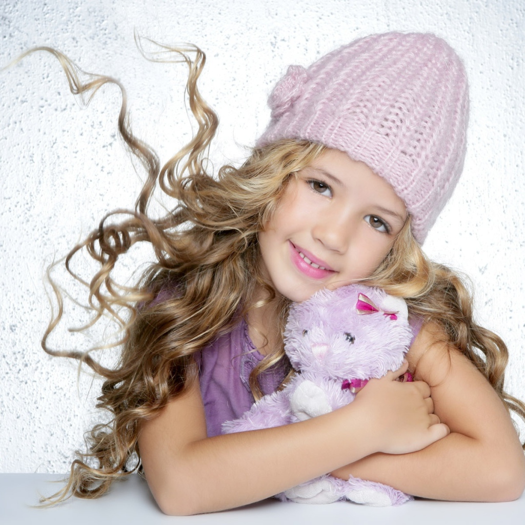 Милая светловолосая девочка с игрушкой