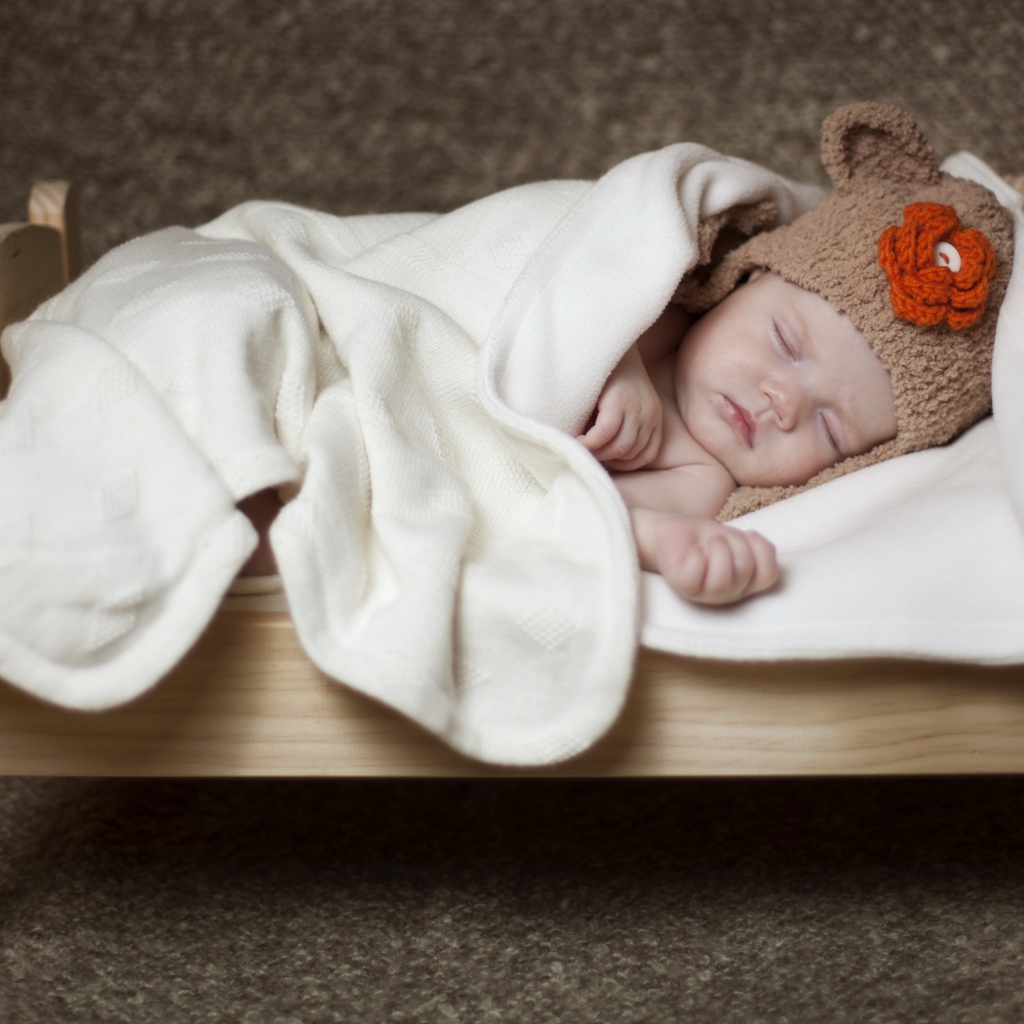 Грудной ребенок спит в маленькой кроватке