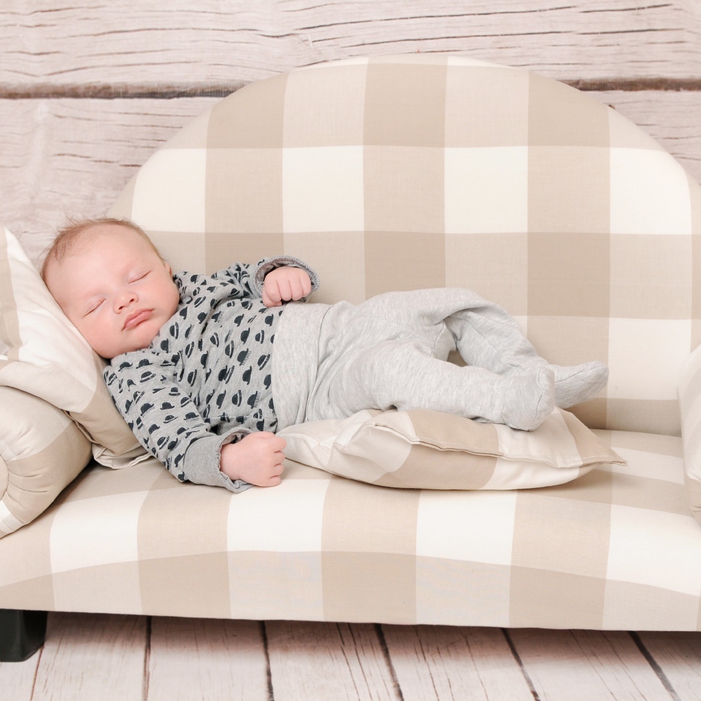 Грудной ребенок спит на диване