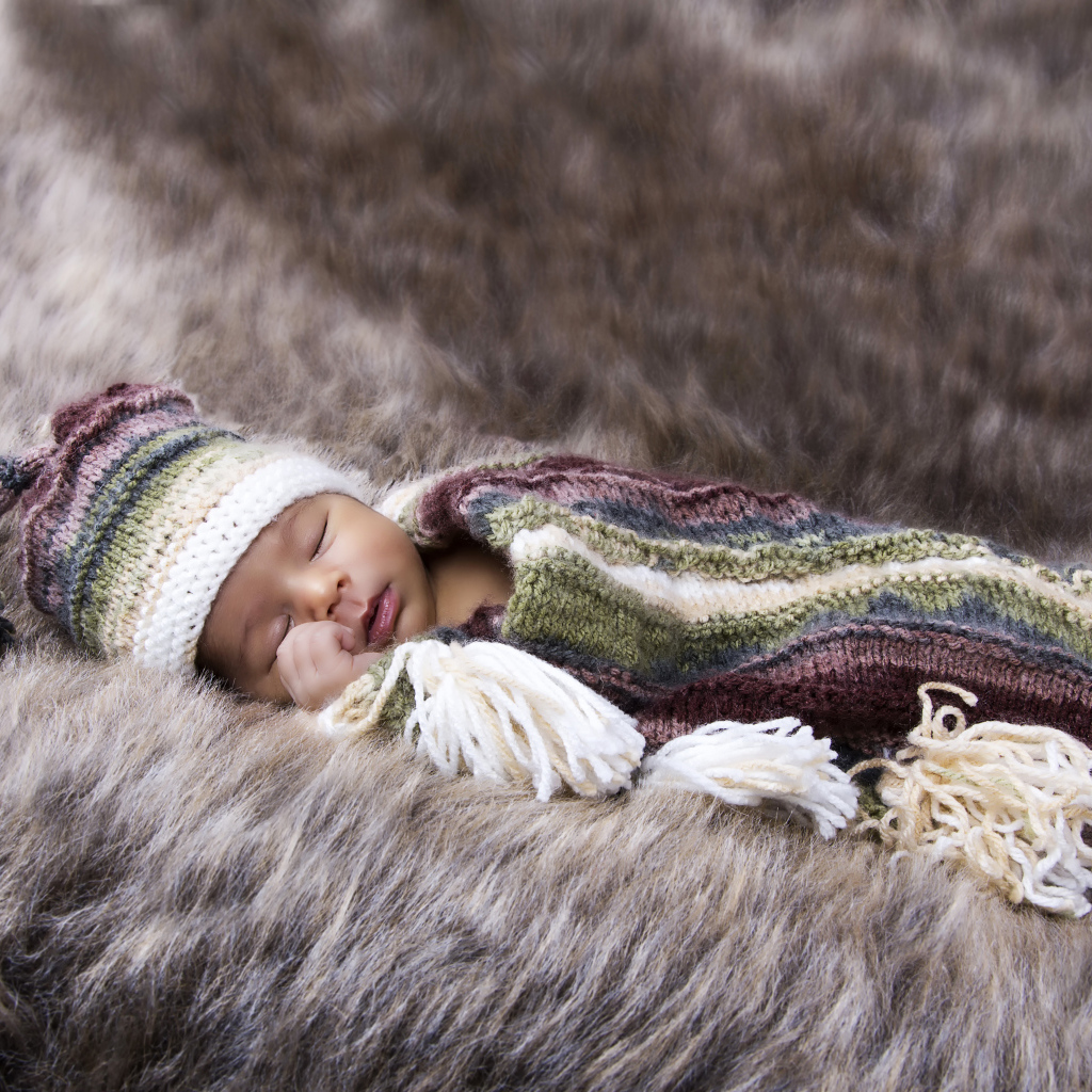 Младенец спит на меховом покрывале
