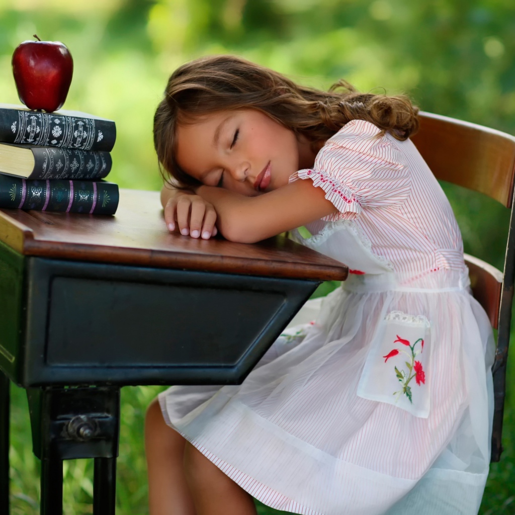 Уставшая маленькая ученица уснула за партой