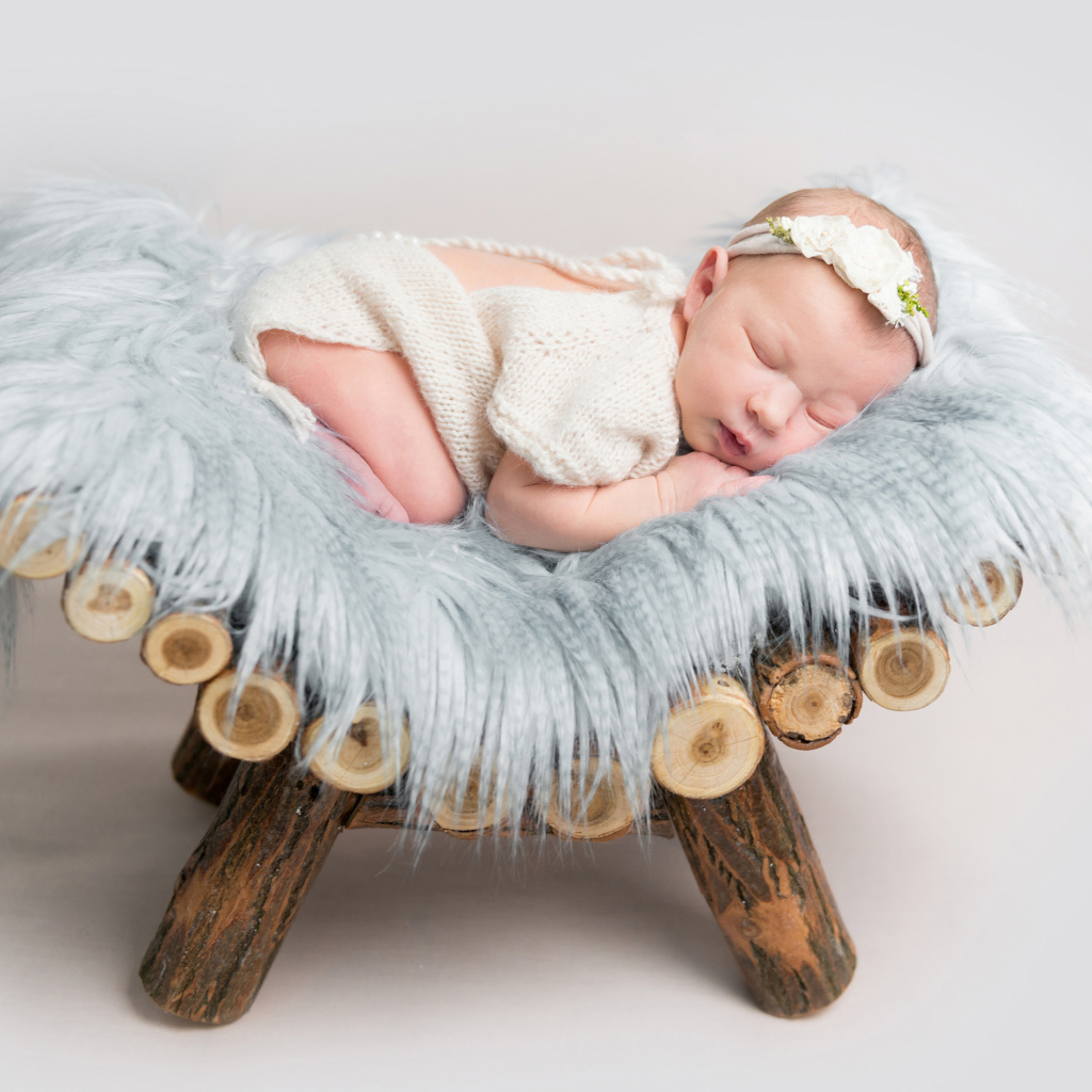 Грудной спящий ребенок лежит на деревянной кроватке