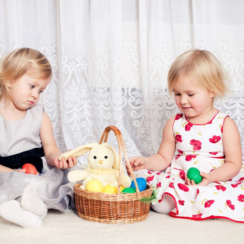 Две маленькие девочки с корзиной пасхальных яиц