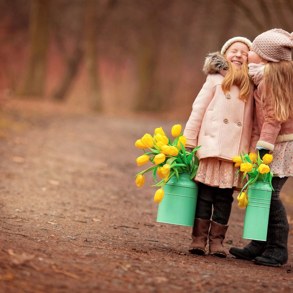 Две маленькие девочки с желтыми тюльпанами весной