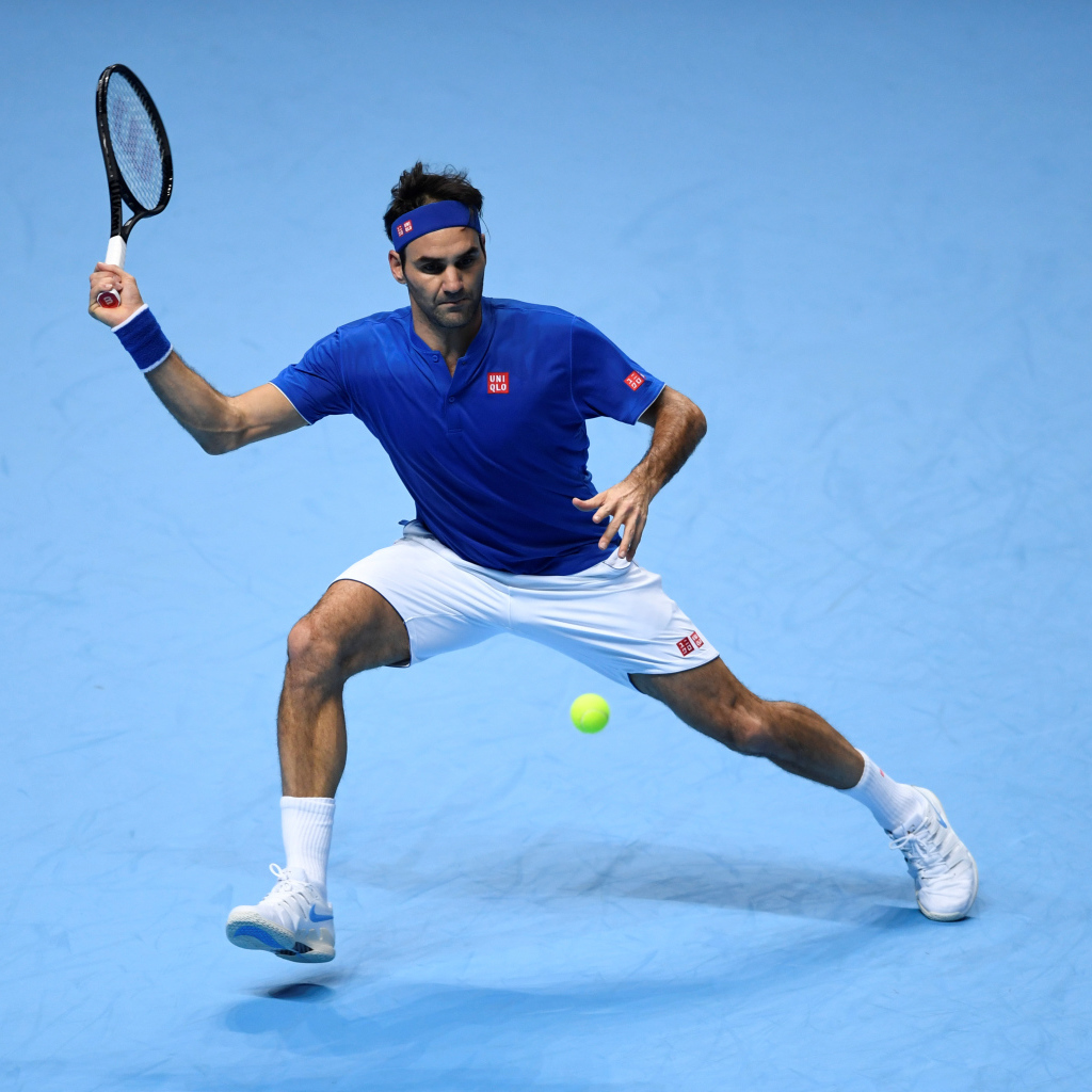 Теннисист Роджер Федерер отбивает мяч ракеткой на корте 