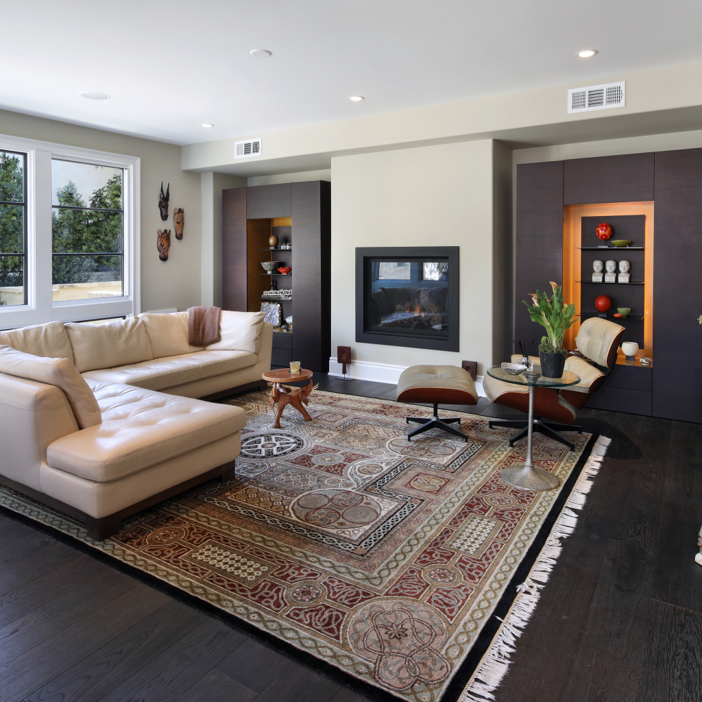 Стильная гостинная комната с белым кожаным диваном и ковром на полу