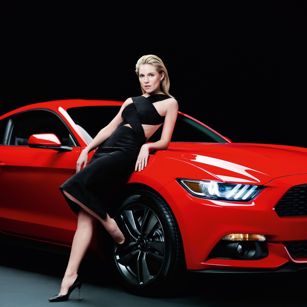 Актриса Сиенна Миллер в черном платье у красного автомобиля Ford Mustang