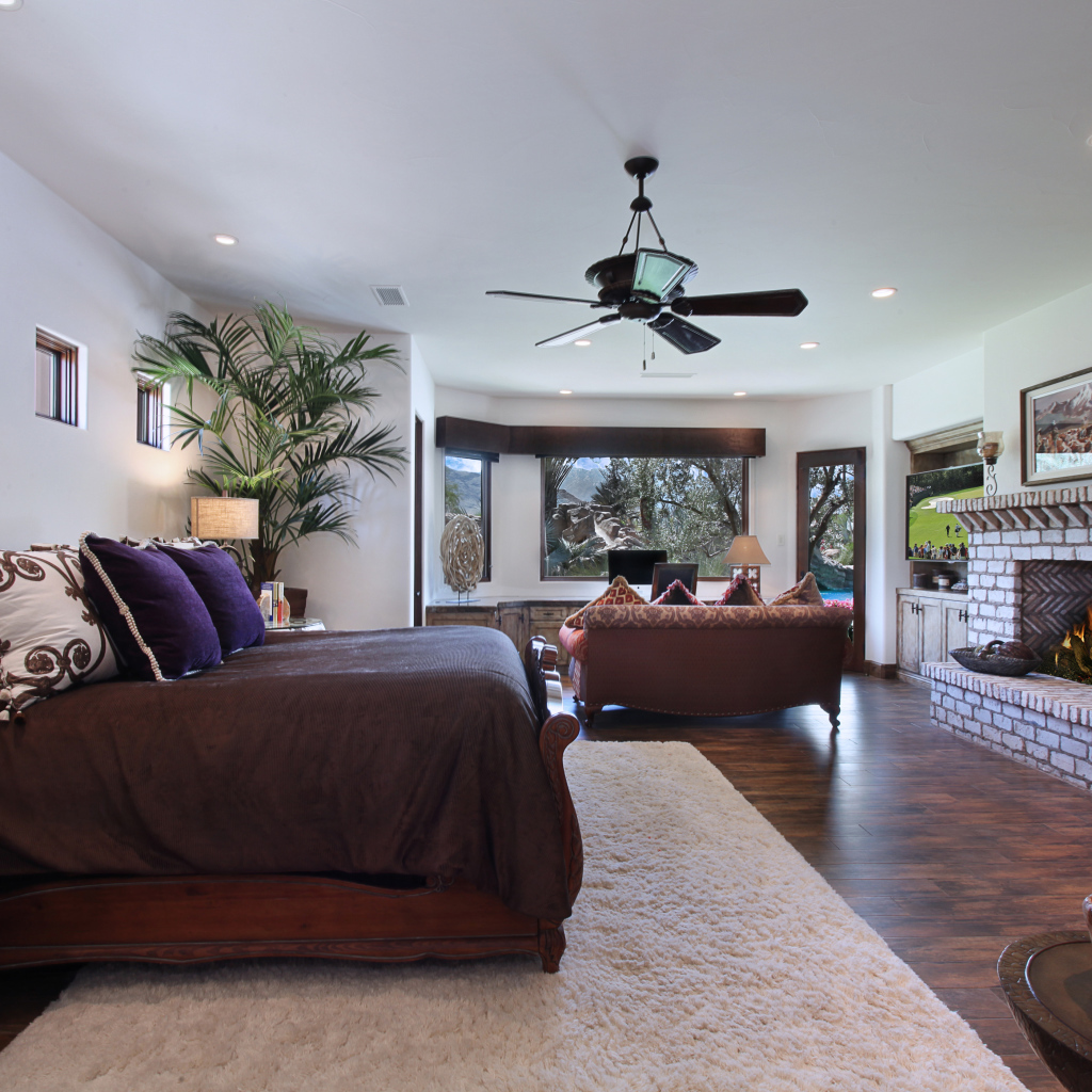 Спальная комната с большой кроватью с камином