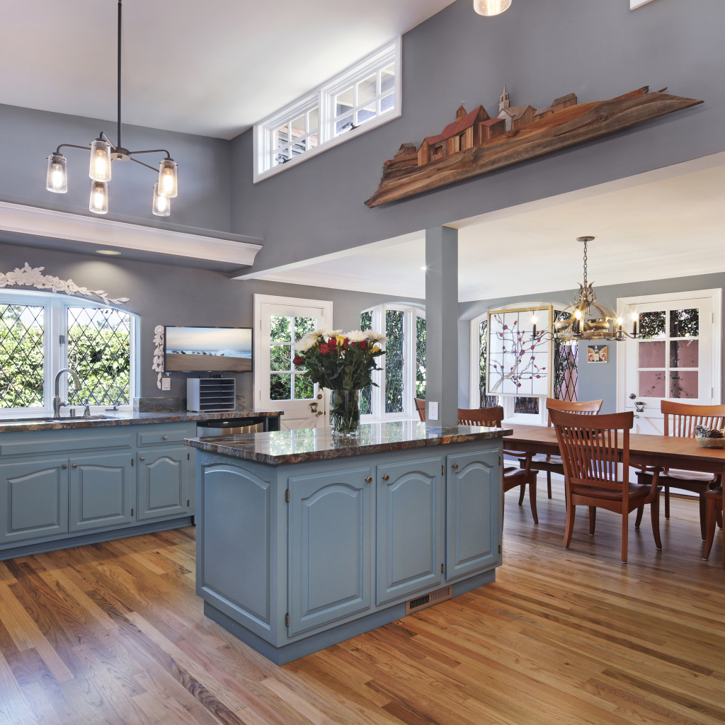 Большая красивая кухня в сером цвете с деревянным столом