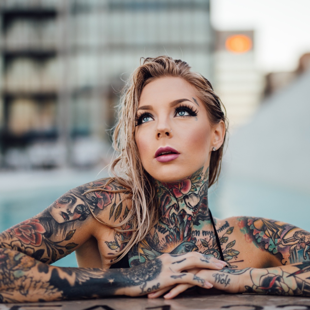 Молодая девушка с красивыми татуировками на теле