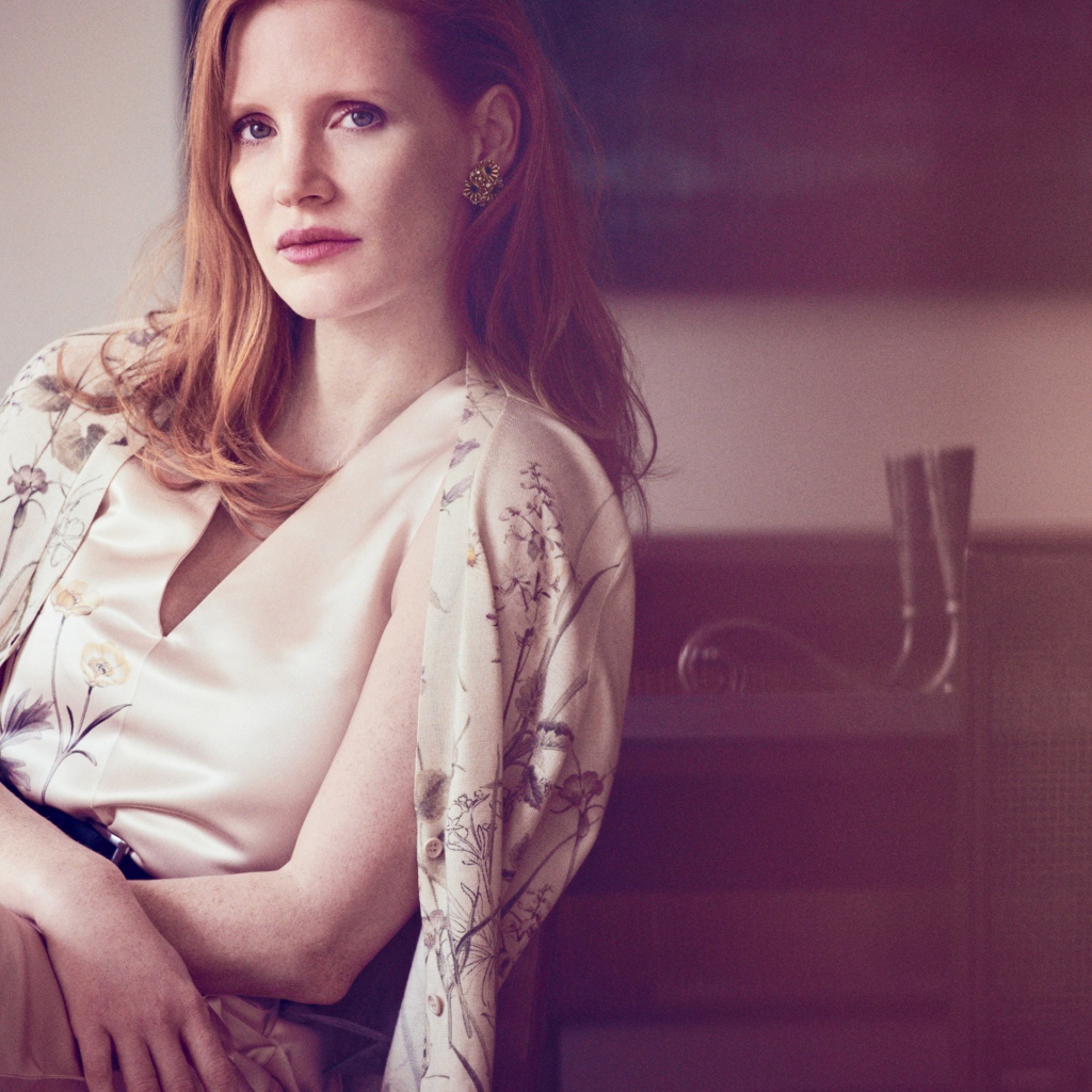 Молодая рыжеволосая актриса Джессика Честейн сидит на стуле