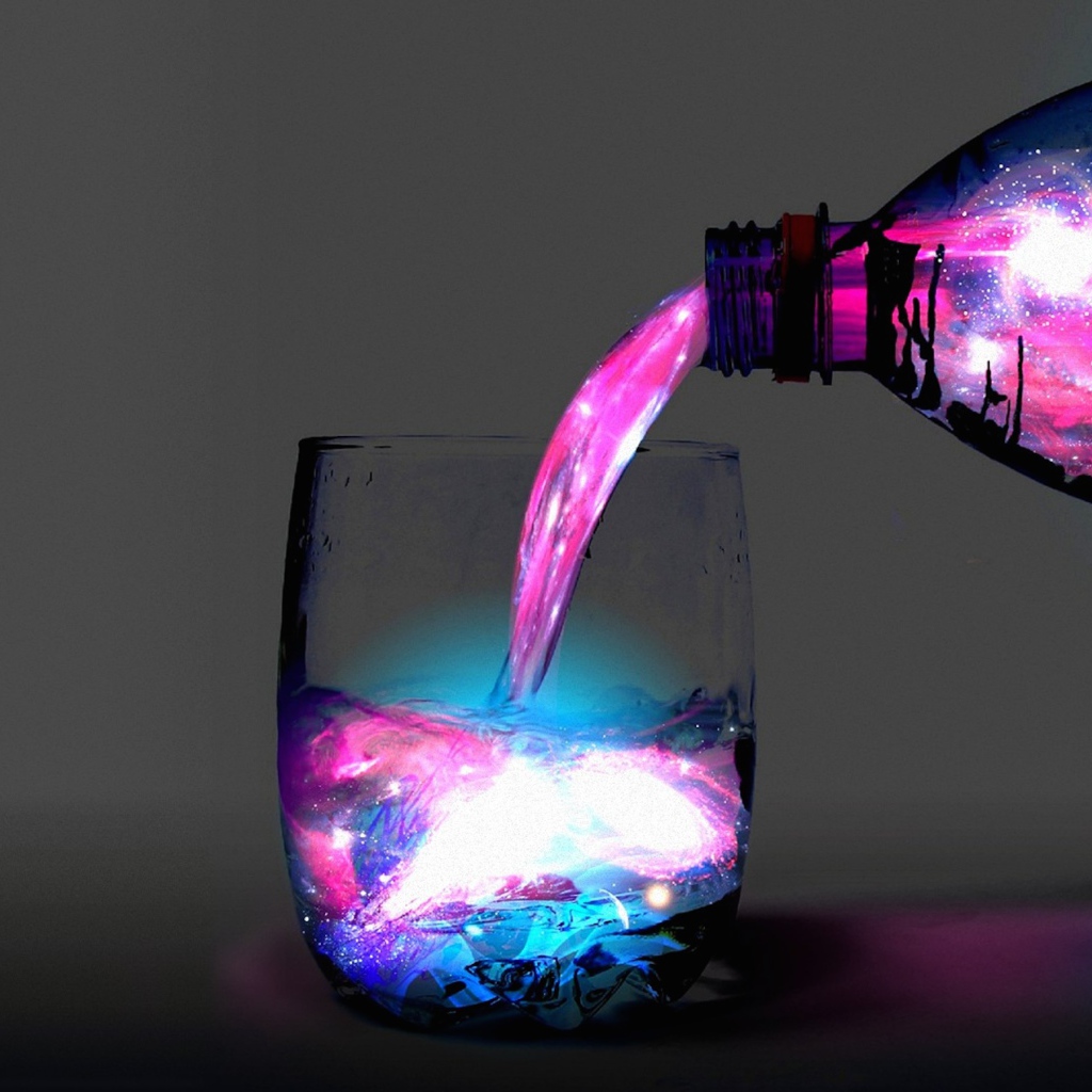 Неоновую воду наливают из бутылки в стакан 