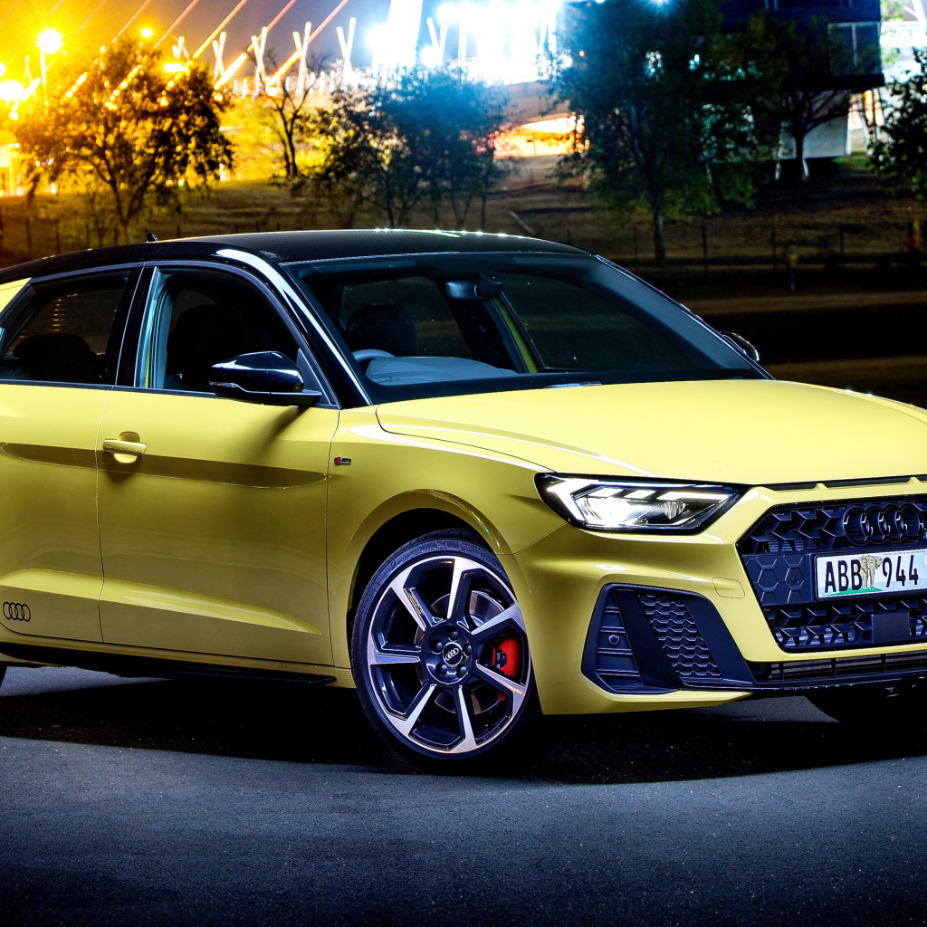 Желтый автомобиль Audi A1 Sportback 40 TFSI S Line Edition One 2019 года на фоне ночного города