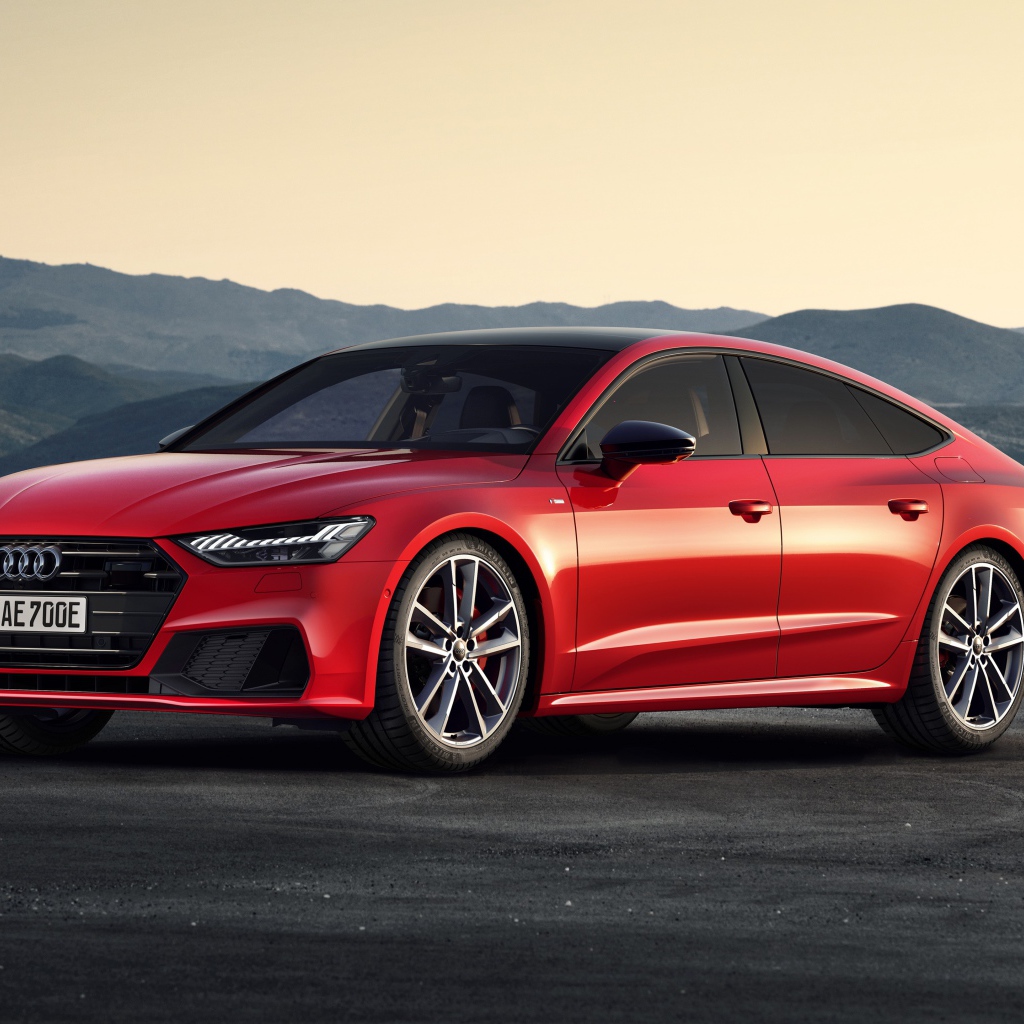 Красный автомобиль Audi A7 Sportback 55 TFSI E Quattro S Line 2019 года в горах