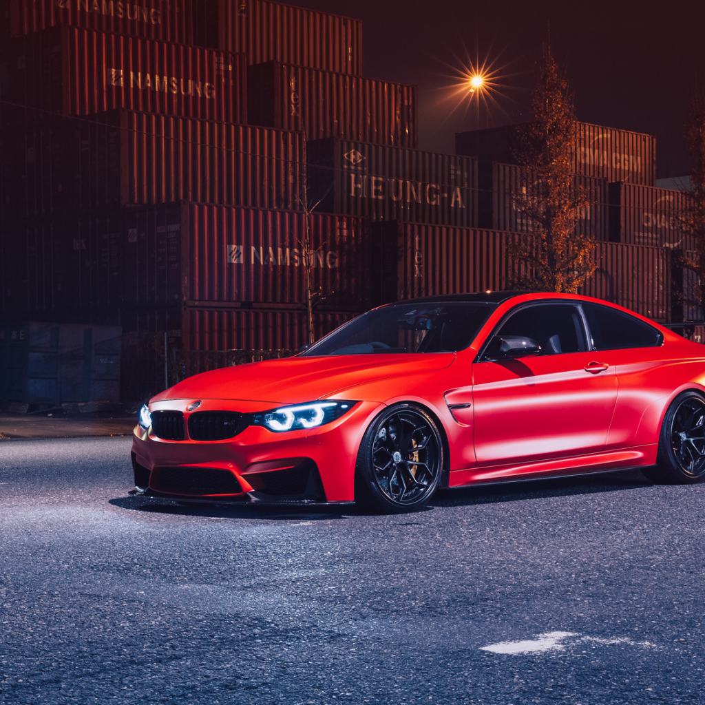 Красный автомобиль BMW M4 на фоне контейнеров