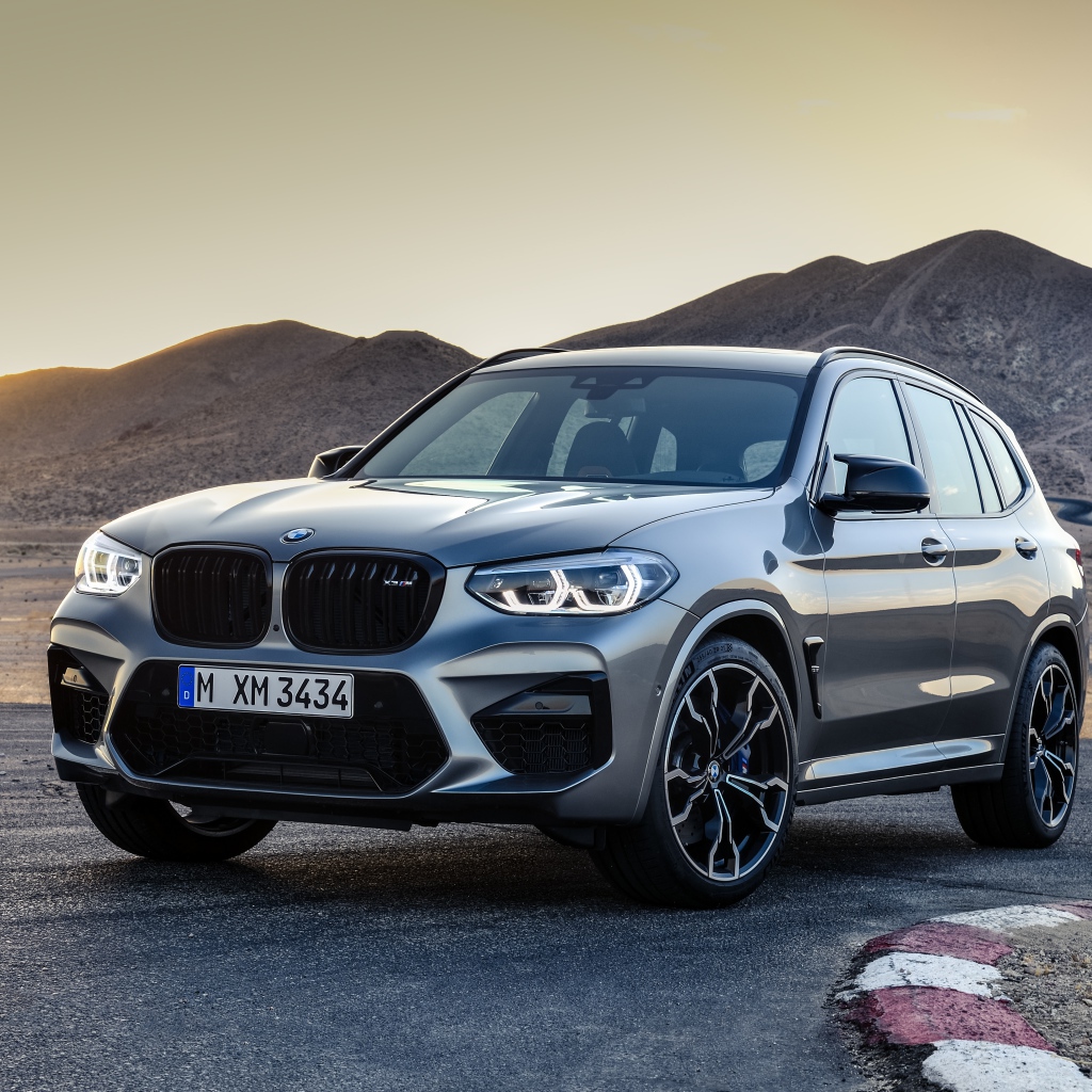 Серебристый автомобиль BMW X3  на асфальте