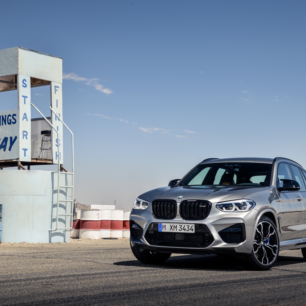 Серебристый автомобиль BMW X3 на асфальте